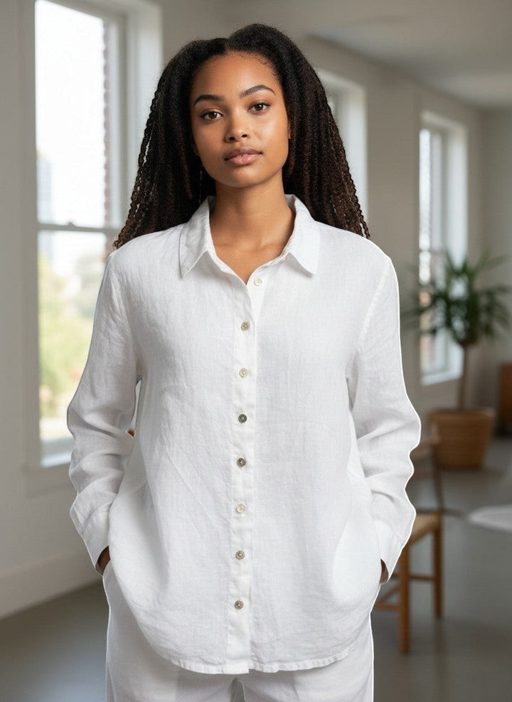 Woman wearing a white shirt in a bright room with large windows