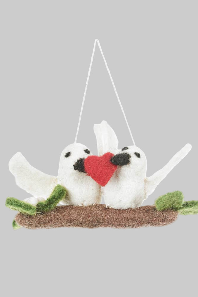 Felted ornament of two birds on a branch with a red heart, hanging from string.
