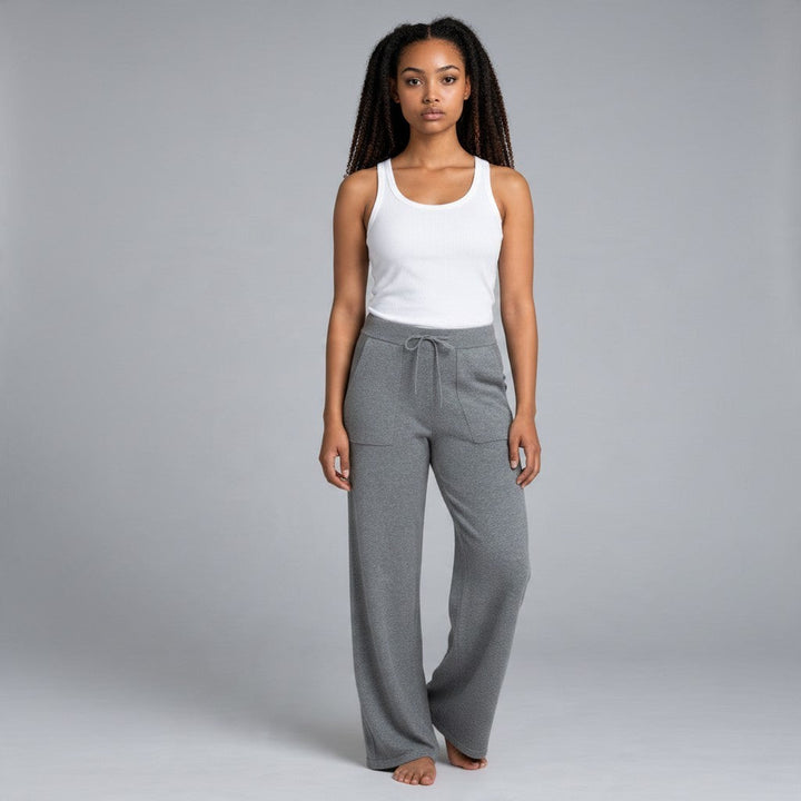 Model wearing Natural Clothing Company Polita grey cotton lounge pants with a wide leg, drawstring, and patch pockets.